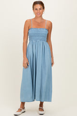 woman wearing a light blue smocked maxi dress with spaghetti straps and a relaxed fit