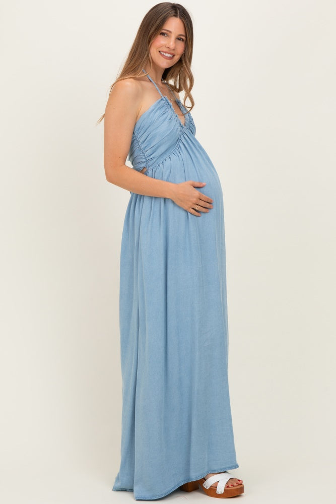 woman wearing a light blue maternity maxi dress with a gathered bodice and holding her baby bump