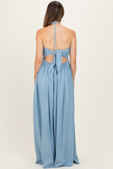 woman wearing a chambray long maternity dress with a halter neck and open back, revealing a baby bump