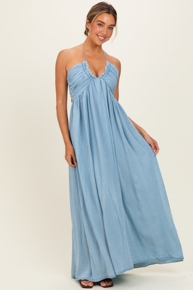 woman wearing a light blue halter neck maxi dress with gathered bodice and flowy skirt