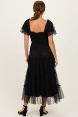 woman wearing a black tiered maxi dress with short puff sleeves and a smocked back