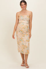 woman wearing a strapless floral maternity dress with ruching, showcasing her baby bump