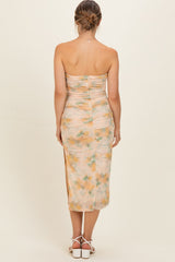 woman wearing a floral print strapless maternity dress with ruched detailing and a knee-length hem