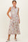 woman wearing a sleeveless floral midi dress with a collar and pockets, standing with a smile