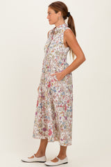 woman wearing a sleeveless floral print midi dress with a collar and pockets