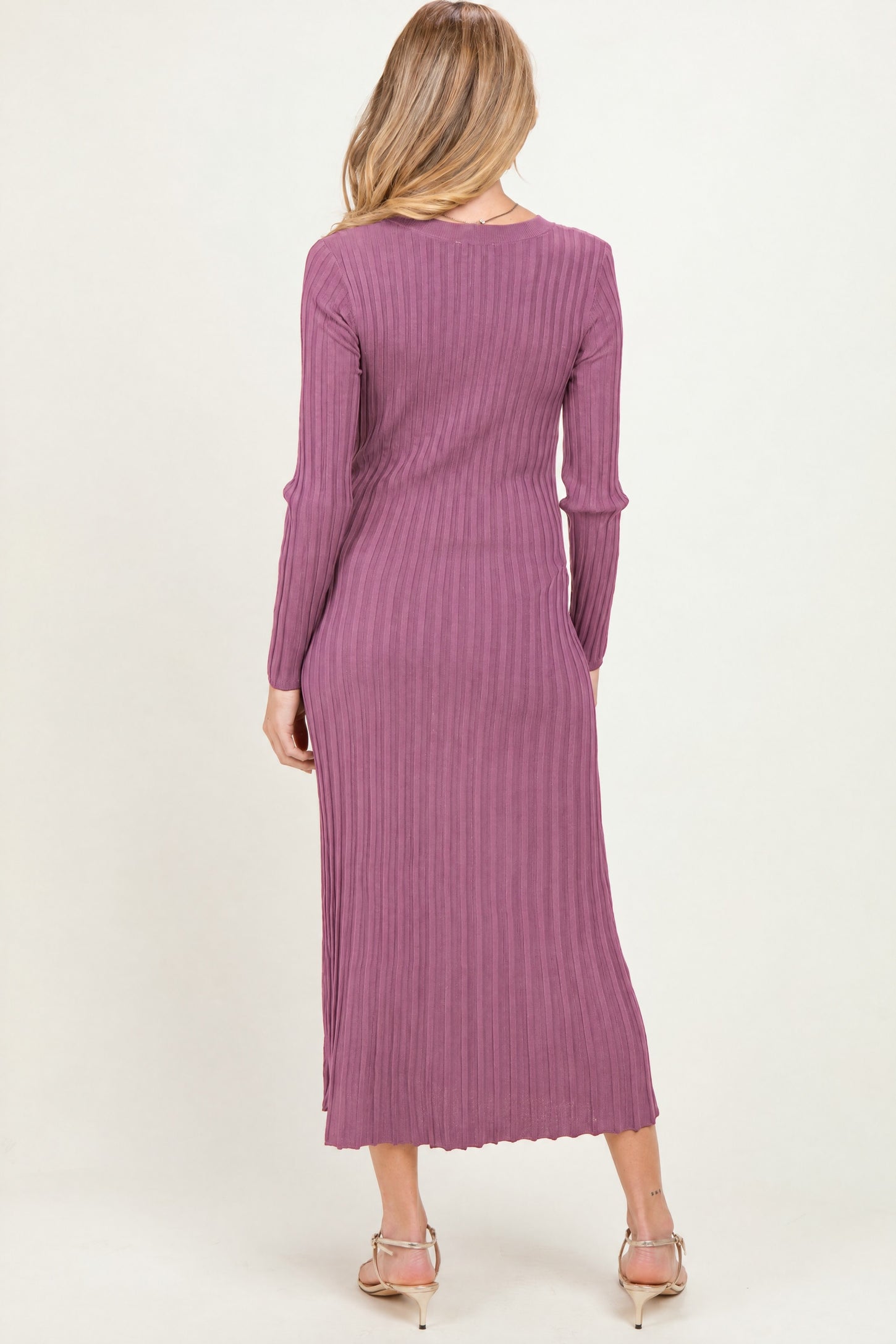 woman wearing a long sleeve ribbed maternity dress in mauve, showing a fitted silhouette and mid-calf length