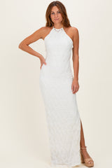woman wearing a white halter neck maxi dress with textured details and a side slit
