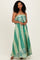 woman wearing a green printed maxi dress with a strapless design and a flowing silhouette