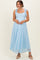 woman wearing a light blue lace maternity dress with tie straps and a flowing skirt, showing a baby bump