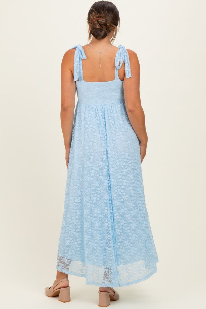 woman wearing a light blue lace maternity maxi dress with tie straps and a flowing skirt, showing her baby bump from behind