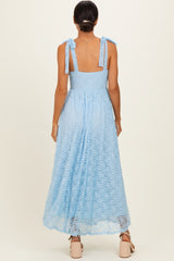 woman wearing a light blue backless maxi dress with tie straps and a flowy silhouette