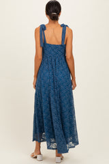 woman wearing a back view of a long blue lace maxi dress with tie shoulder straps