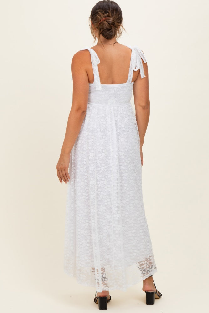 woman wearing a white lace maternity maxi dress with tie straps, showing the back view and a flowing silhouette