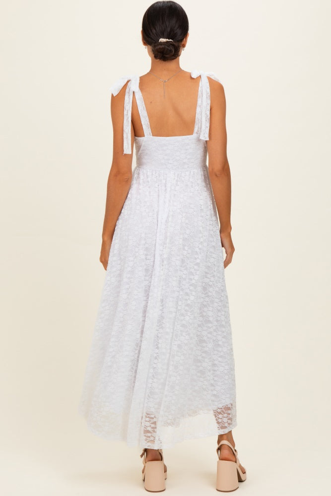 woman wearing a white lace maxi dress with tied straps and a flowing silhouette, shown from the back