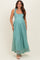 woman wearing a light teal maternity maxi dress with tie shoulder straps and intricate lace detailing
