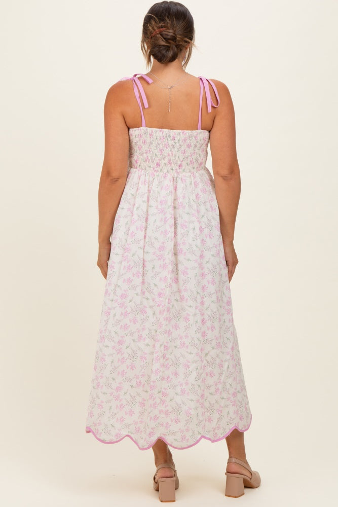 woman wearing a floral maternity maxi dress with adjustable straps and a smocked back, showcasing a flowing silhouette