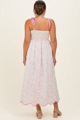 woman wearing a floral maternity maxi dress with adjustable straps and a smocked back, showcasing a flowing silhouette