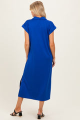 woman wearing a blue maternity polo dress with short sleeves and side slits, showing a relaxed fit from the back