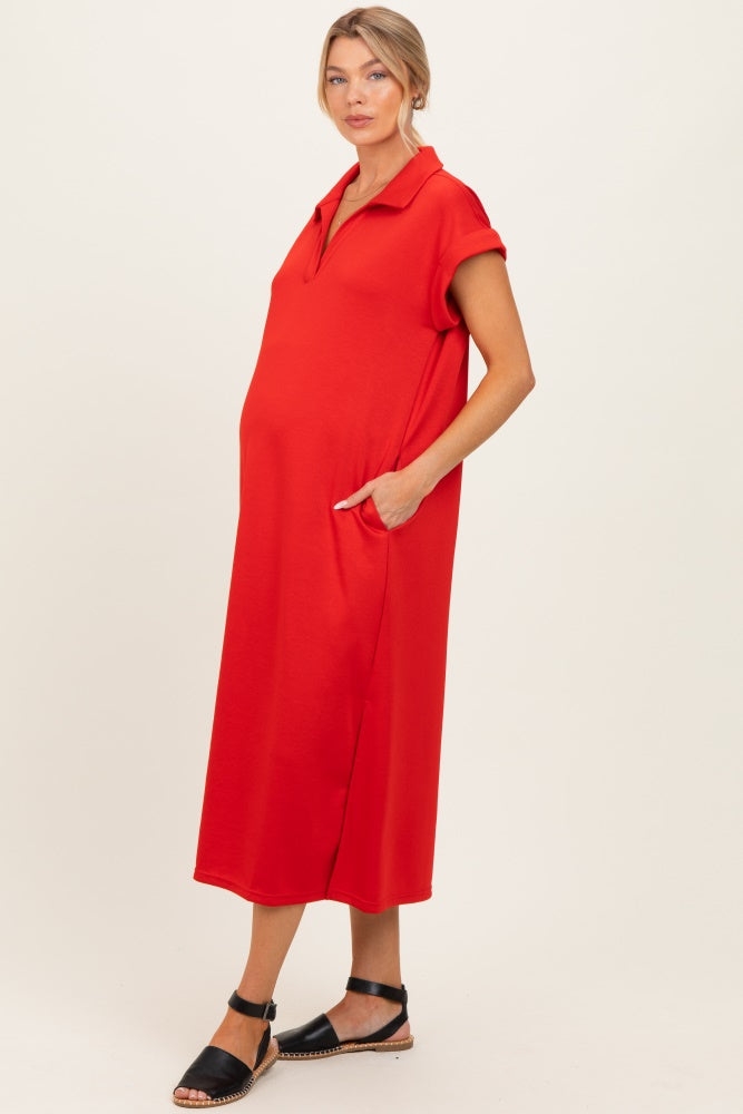 woman wearing a red collared maternity dress with side pockets and short sleeves, showcasing her baby bump