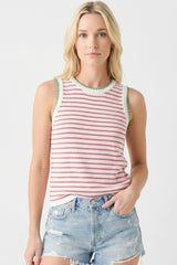 woman wearing a red and white striped sleeveless top with green trim and distressed denim shorts