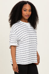 woman wearing a white and gray striped oversized t-shirt with rolled sleeves and a relaxed fit