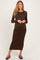 woman wearing a brown long sleeve maternity dress and showing her baby bump