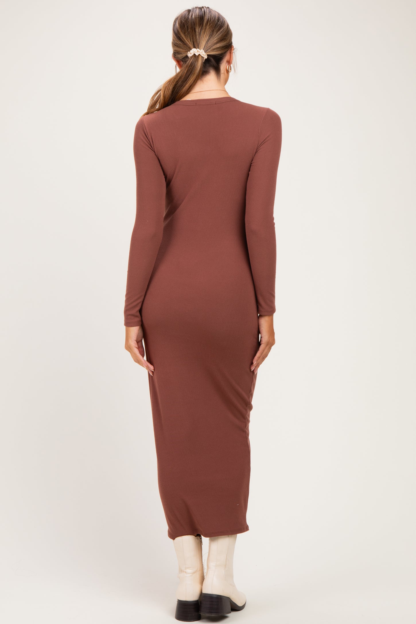 woman wearing a rust long sleeve maternity maxi dress, seen from the back