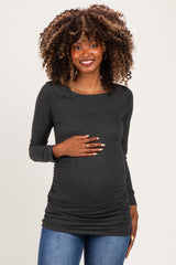 woman wearing a dark gray long sleeve maternity top with ruching and holding her baby bump