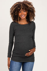 woman wearing a dark grey long sleeve maternity top and holding her baby bump