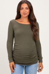 woman wearing an olive green long sleeve maternity top with side ruching and a visible baby bump