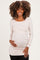 woman wearing a light beige long sleeve maternity top and holding her baby bump