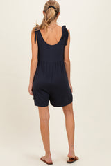 woman wearing a navy maternity romper with tie sleeve details and a relaxed fit