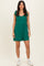 woman wearing a green sleeveless romper with tie detail on the shoulders