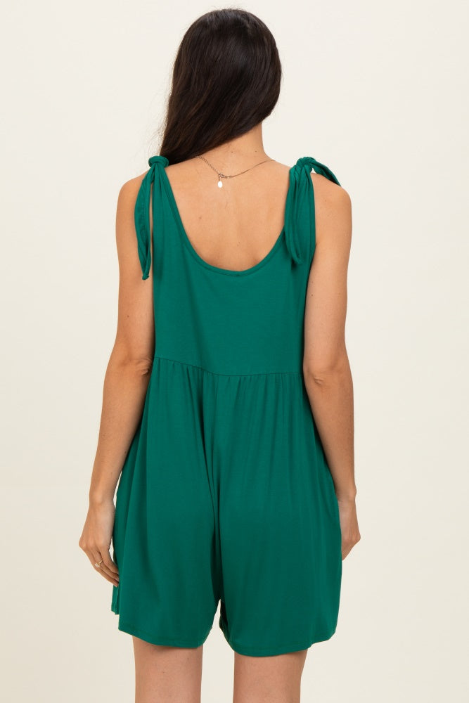 woman wearing a sleeveless green romper with tie straps and a flowy fit from the back