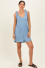 woman wearing a light blue sleeveless romper with tie straps and a cinched waist