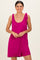 woman wearing a fuchsia sleeveless romper with tie shoulder details and a comfortable fit
