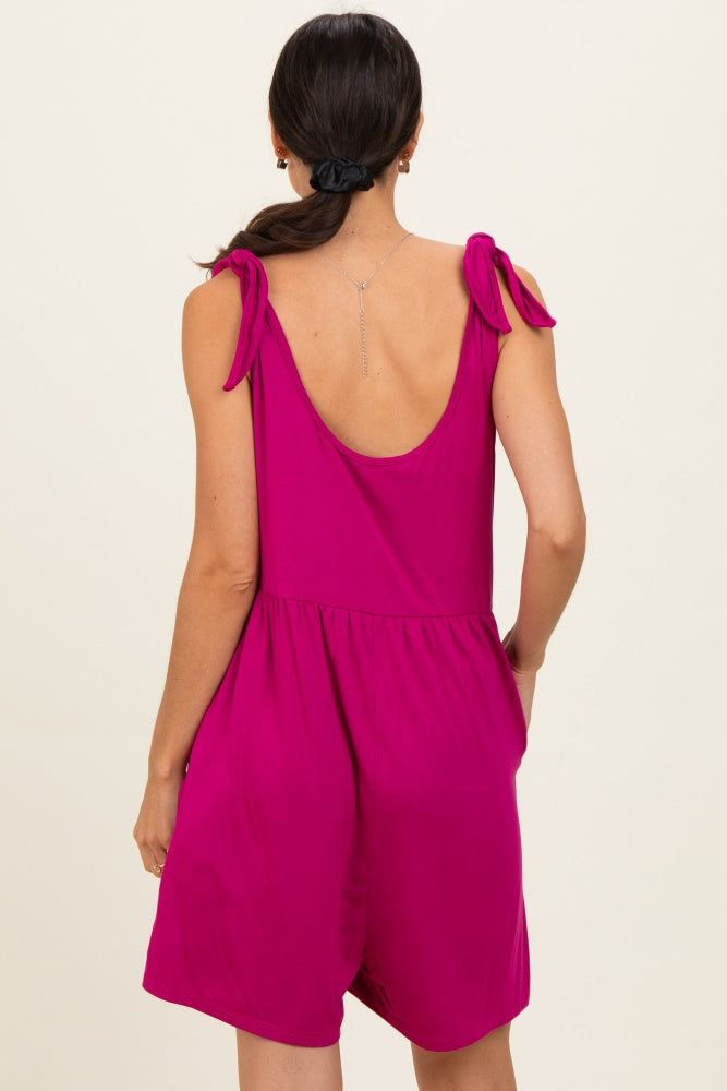 woman wearing a fuchsia sleeveless romper with tie shoulder details and a loose fit, view from the back
