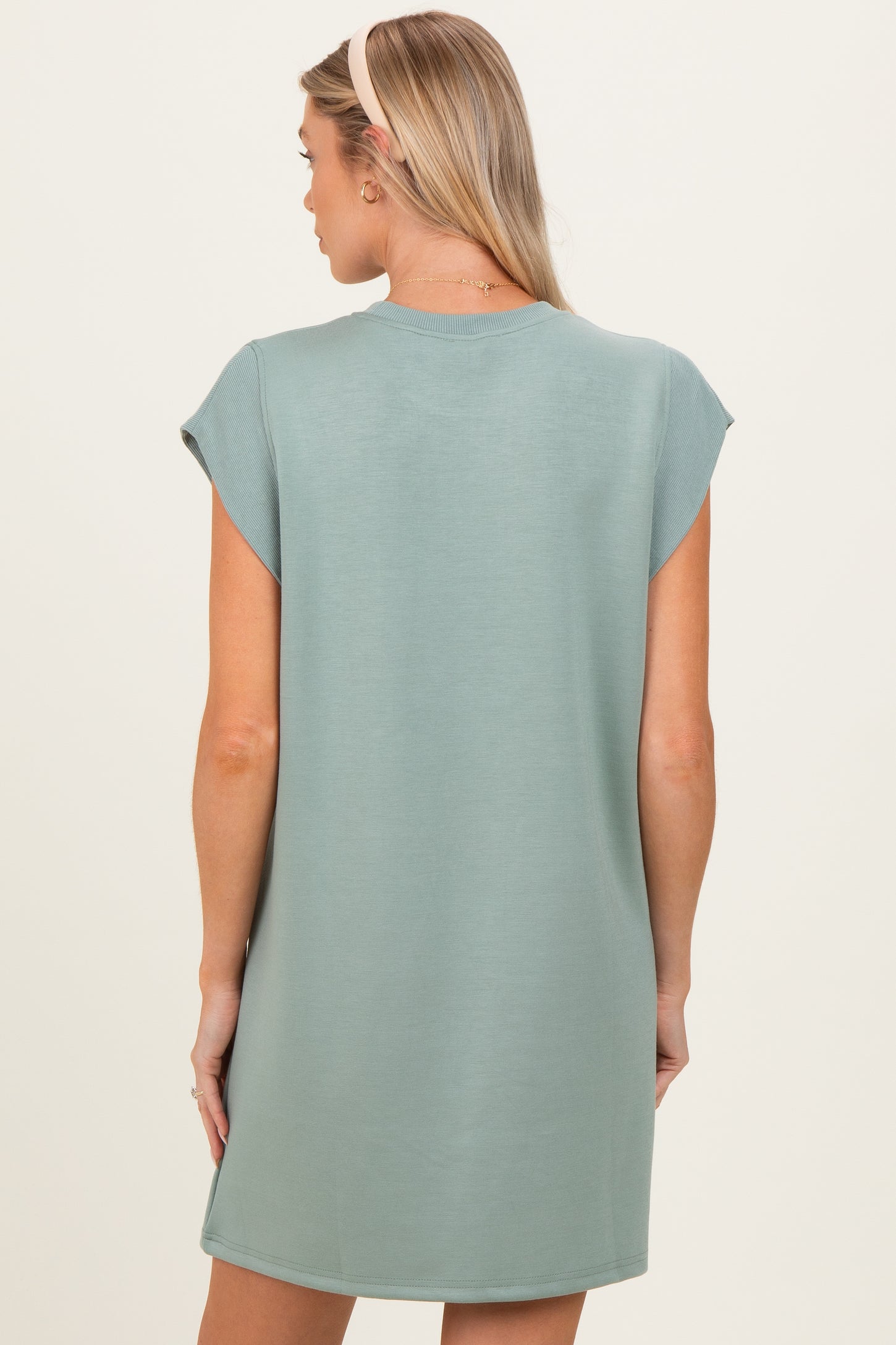 woman wearing a light green short sleeve maternity dress, view from the back