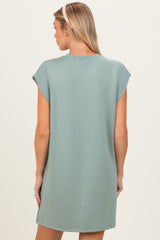 woman wearing a light green short sleeve maternity dress, view from the back