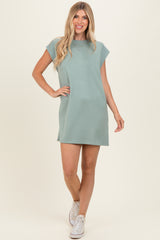 woman wearing a relaxed fit sage green short sleeve dress and white sneakers