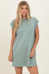 woman wearing a relaxed fit sage green t-shirt dress with short sleeves and a crew neck