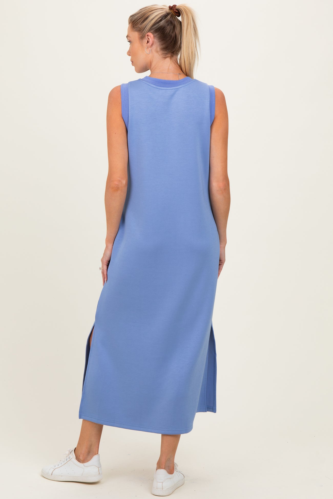 woman wearing a light blue sleeveless maternity maxi dress with side slits