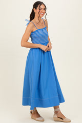 woman wearing a bright blue smocked maxi dress with spaghetti straps and espadrille wedges
