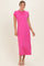 woman wearing a bright pink short sleeve maxi dress standing against a neutral background