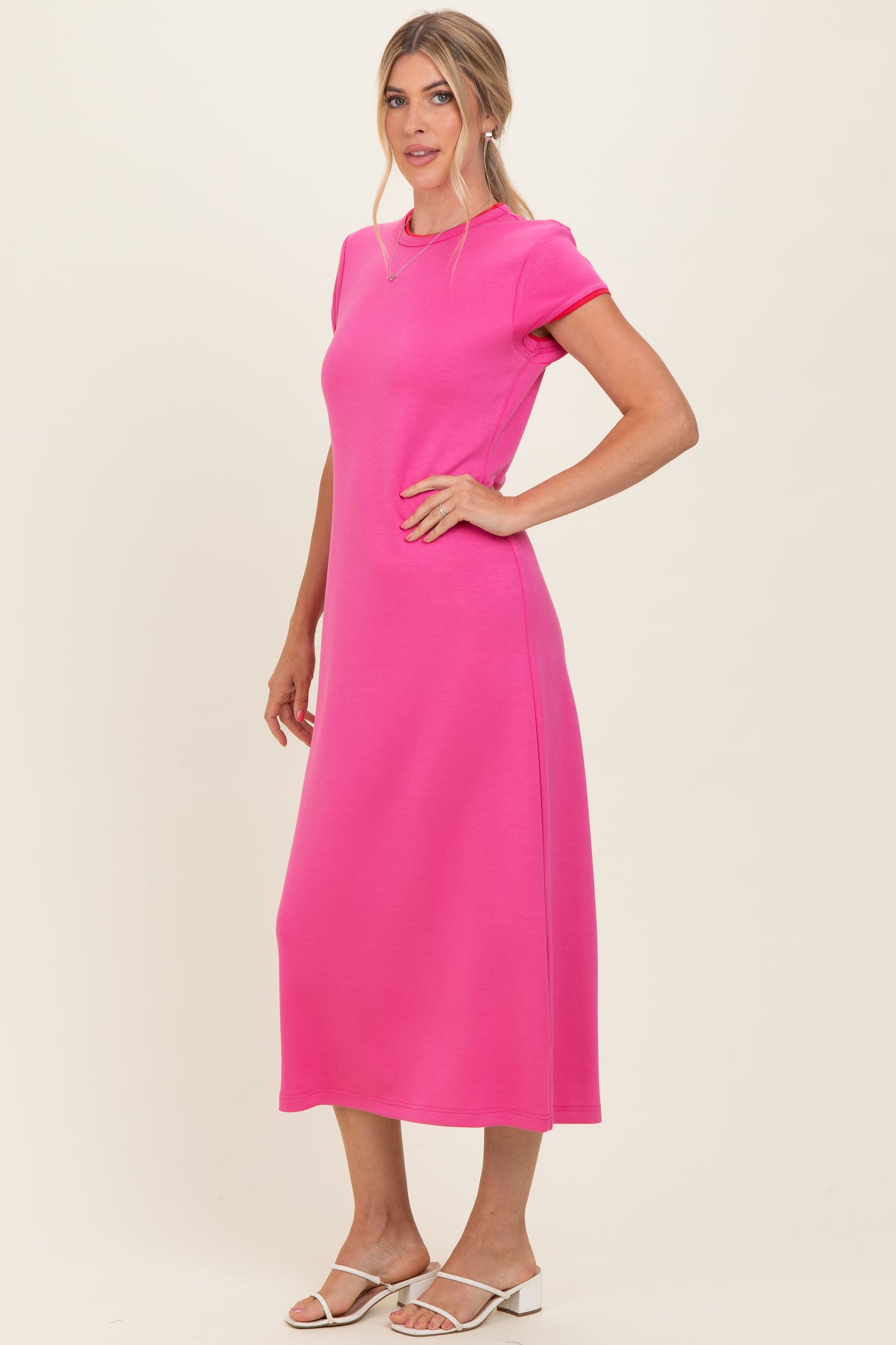 woman wearing a bright pink short sleeve maxi dress with a relaxed fit and side slits