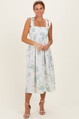 woman wearing a white floral midi dress with smocked bodice and tie straps