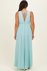 woman wearing a light blue backless maternity maxi dress with a tie detail and smocked waist
