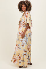 woman wearing a floral yellow maxi dress with flutter sleeves and a visible baby bump