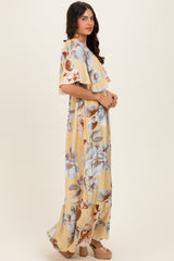woman wearing a yellow floral maxi dress with ruffled sleeves and a relaxed fit, standing sideways