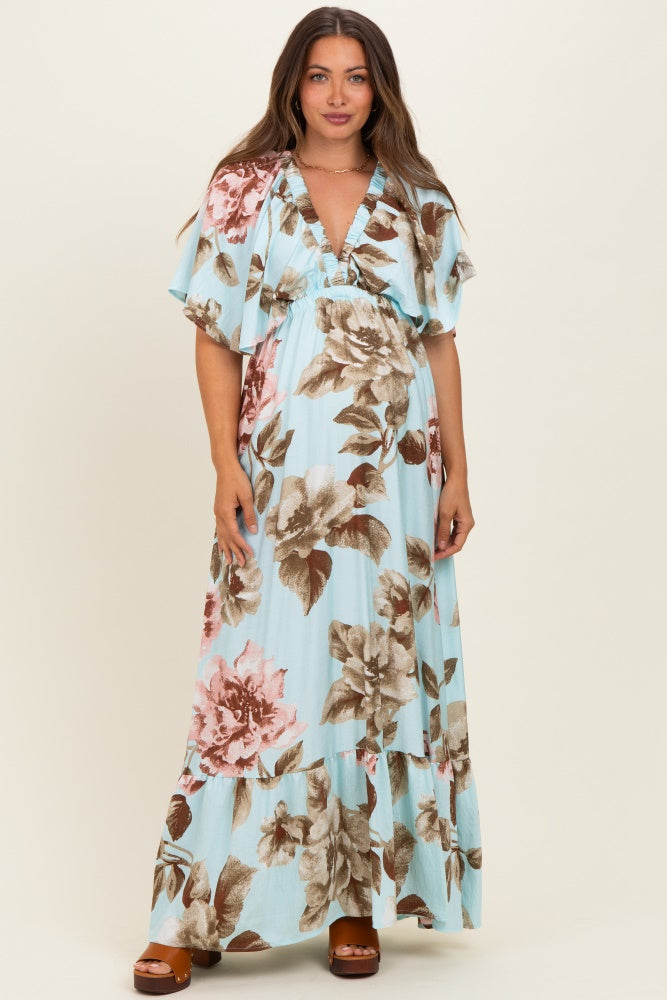 woman wearing a light blue floral maternity maxi dress with a deep v-neck and flutter sleeves, showing her baby bump
